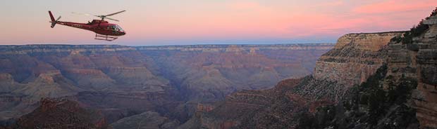 An helicopter flying in the sunset in the Grand Canyon.